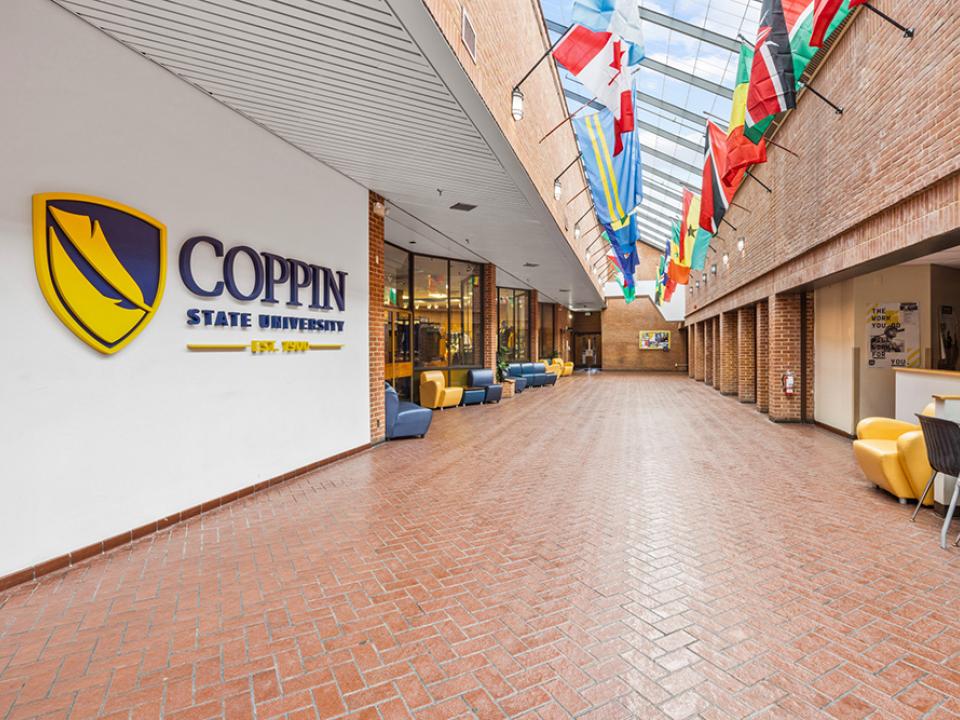Tawes Center Lobby includes a long wide hallway with seating and flags from around the world mounted below a long stretch of skylights